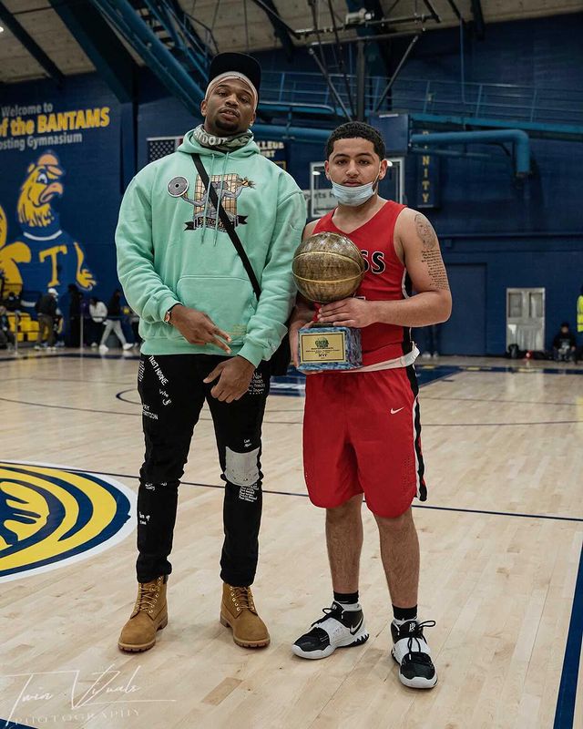 Daniel Lee Bellomy in sky blue hoodie and black pants with a basketball player in a red jersey.